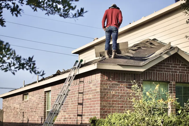 Professional roofer working on a residential roof in River Edge